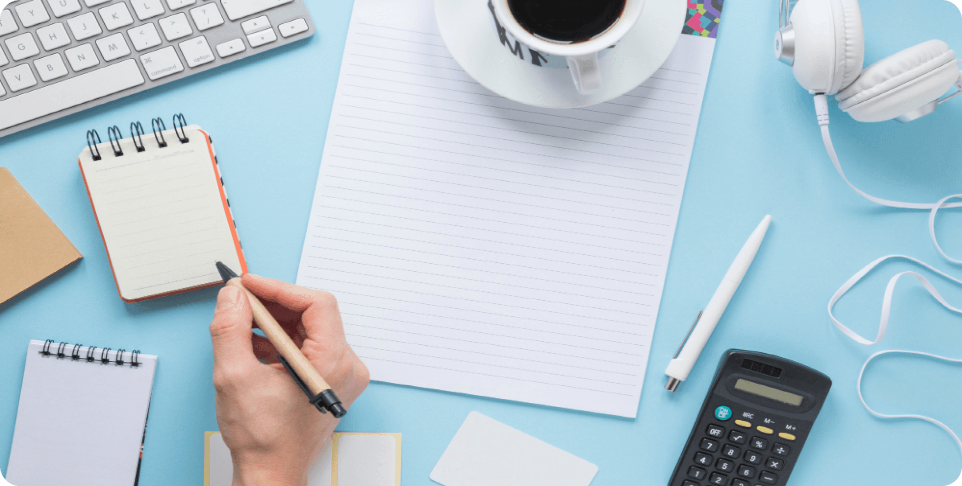 Financial planning workspace with notebook, calculator, and coffee