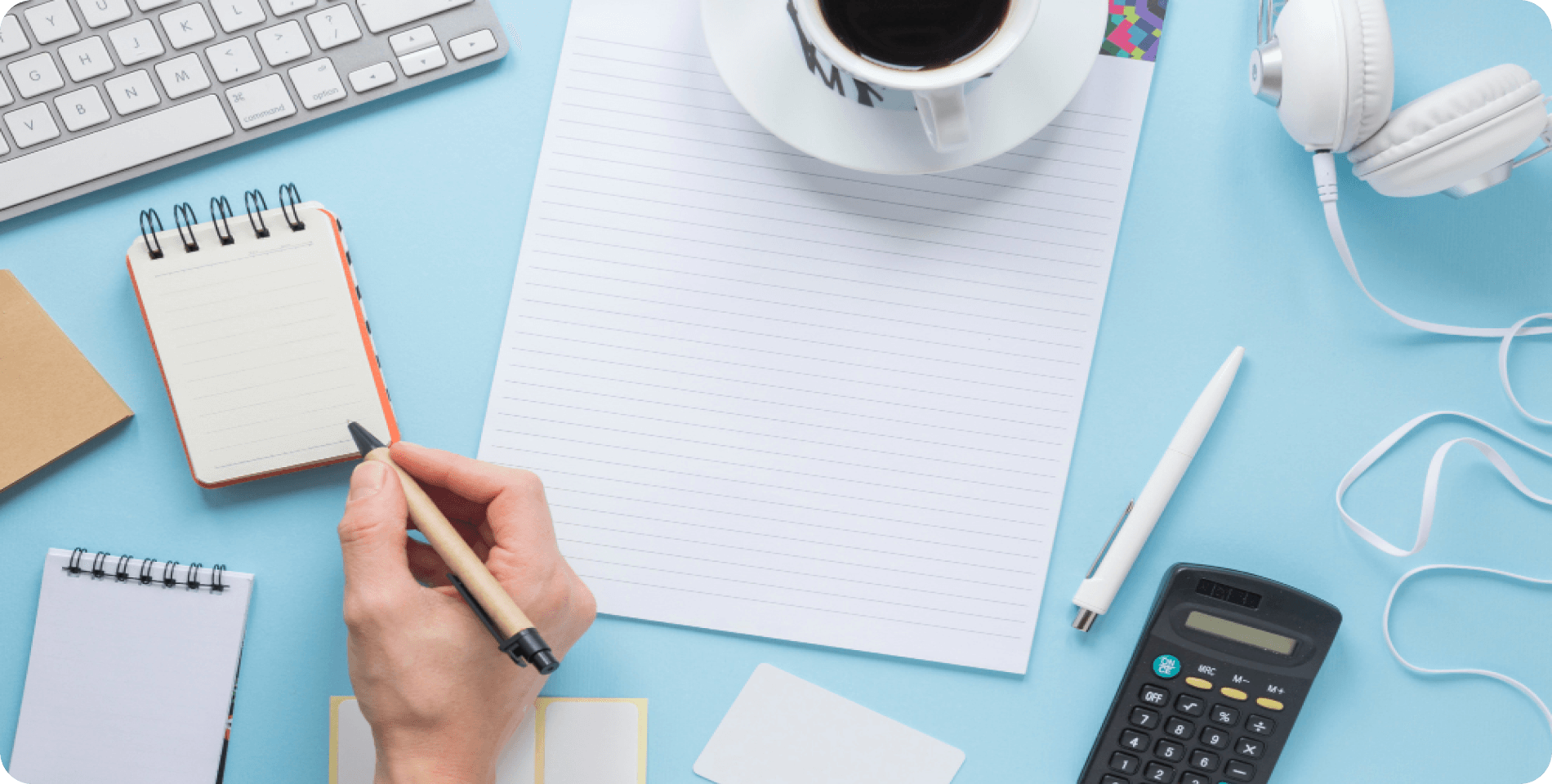 Financial planning workspace with notebook, calculator, and coffee